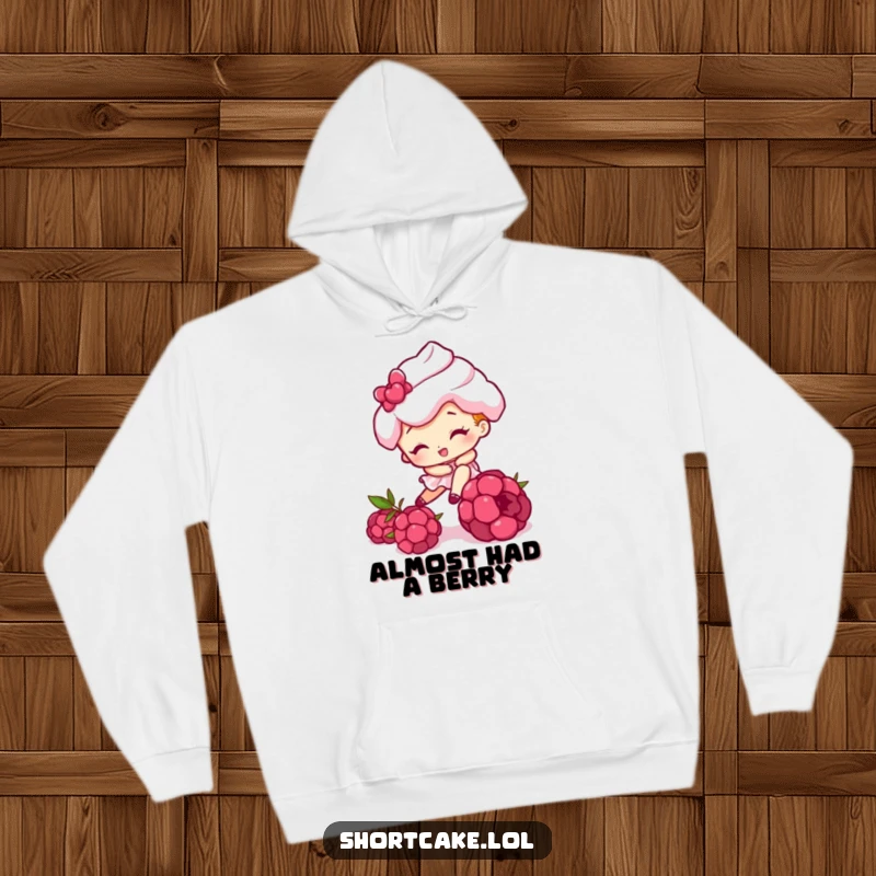 Funny hoodie with a shortcake character hilariously tripping over a raspberry, perfect for staying warm and amused.
