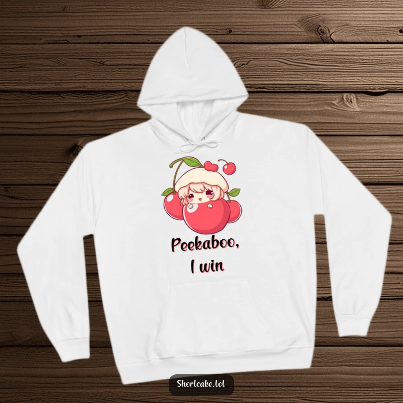 Funny Hoodie showing a shortcake character peeking from behind a large cherry, offering warmth and delightful, humorous appeal.