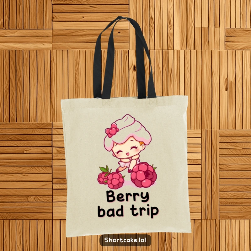 Funny tote bag featuring a shortcake character comically tripping over a raspberry, perfect for carrying items with a humorous twist.